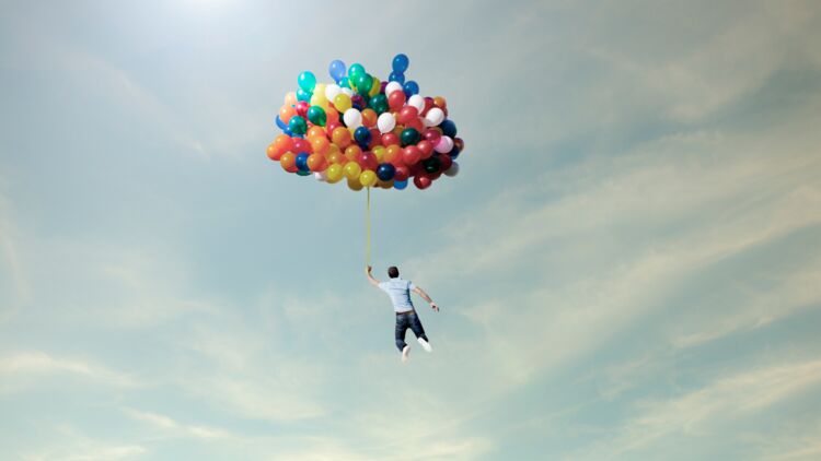 man lifted into sky by huge bunch of balloons