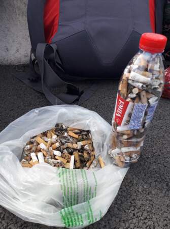 Remplir une bouteille de mégots de cigarette trouvés sur le bord de la route