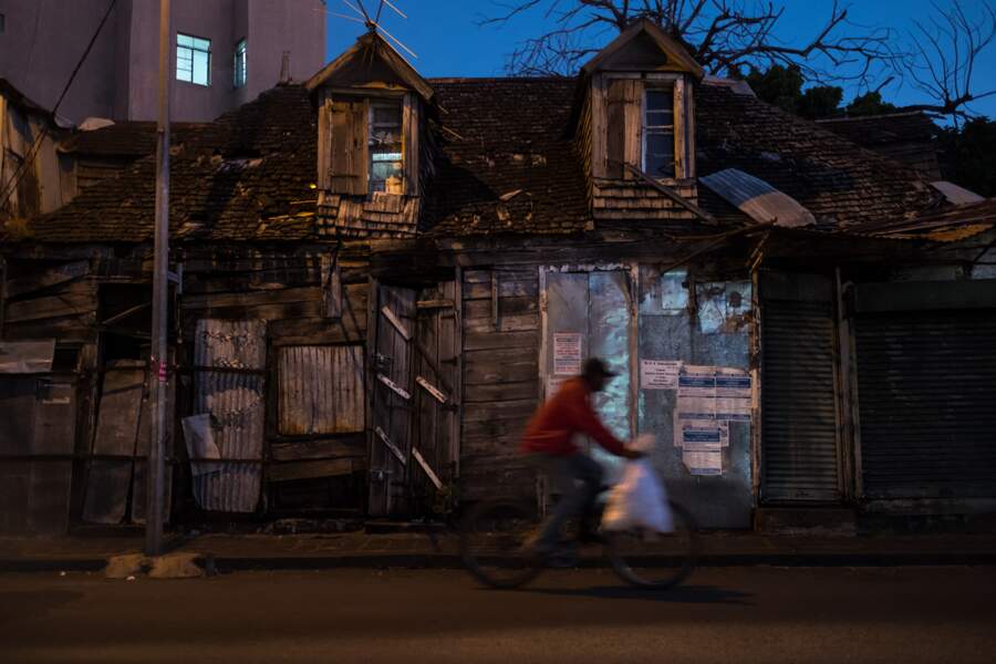 Un cycliste passe devant une vieille maison créole de Port Louis, la capitale
