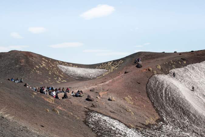 Les touristes sont attirés par le feu du volcan comme une nuée d'insectes