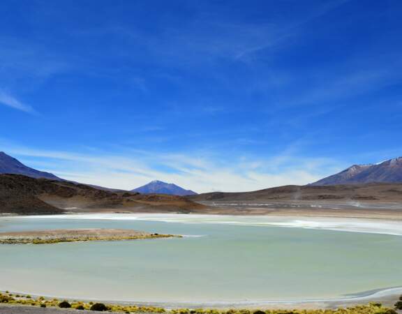 Vaste désert de sel avec présence d'un lac, en Bolivie