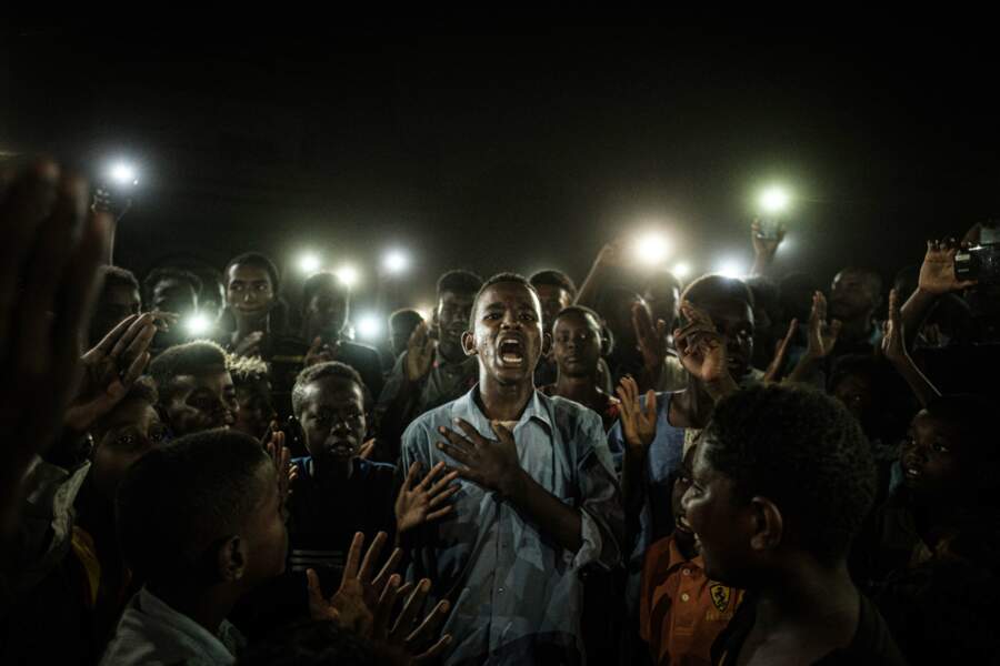 Un jeune homme récite un poème tandis que des manifestants scandent des slogans appelant à un régime démocratique lors d'une panne de courant à Khartoum, au Soudan, le 19 juin 2019 - Catégories "Photo de l'année" et "Infos générales" (série)