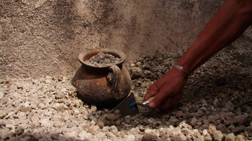 Un récipient pour la cuisson des aliments émerge du lapilli lors de l’excavation