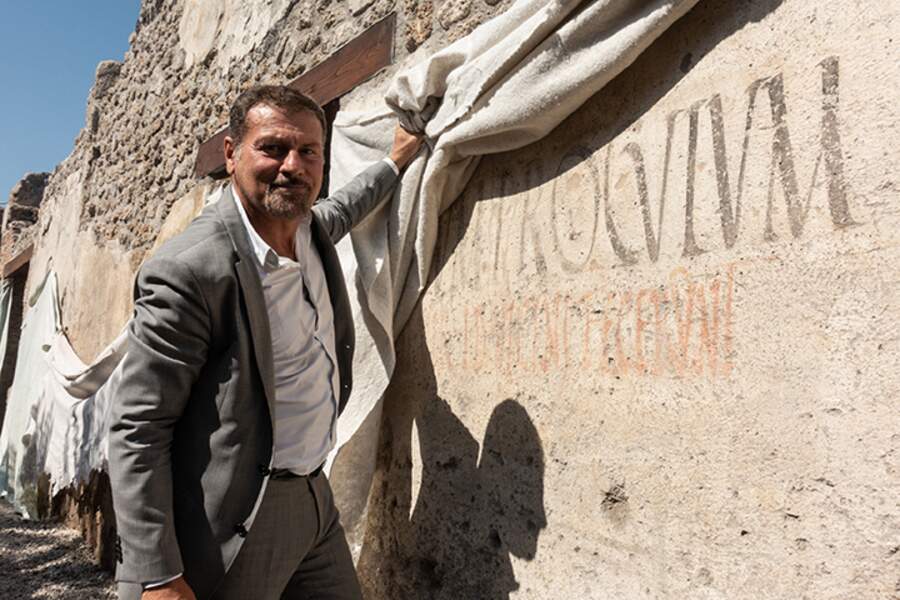 En septembre 2018, le directeur général du parc archéologique de Pompéi, le professeur Massimo Osanna, devant une inscription électorale peinte