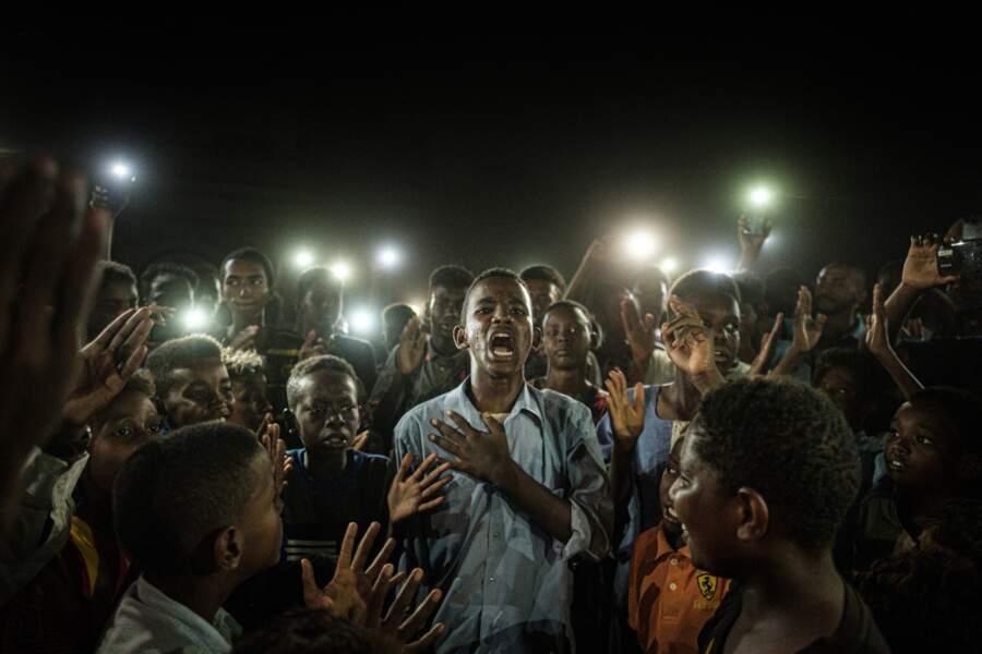 Un jeune homme récite un poème au milieu d’un groupe de manifestants. Khartoum, Soudan, 19 juin 2019