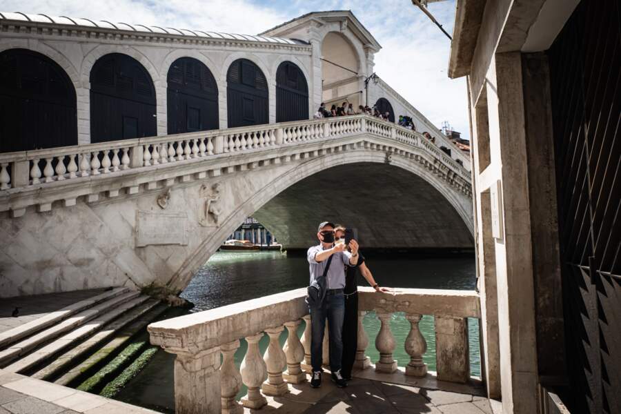 Des touristes italiens se photographiant devant le pont du Rialto