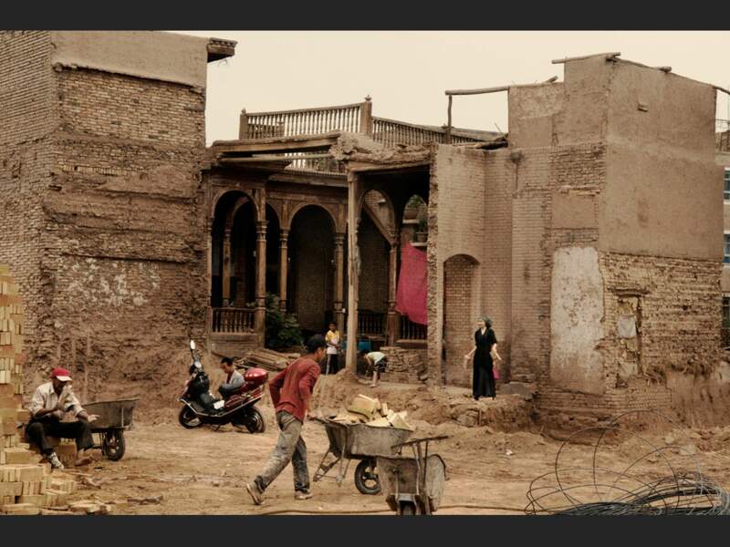 Cette famille nettoie les gravats d'un mur de leur maison abattu par les autorités, à Kachgar, dans le Xinjiang, en Chine.