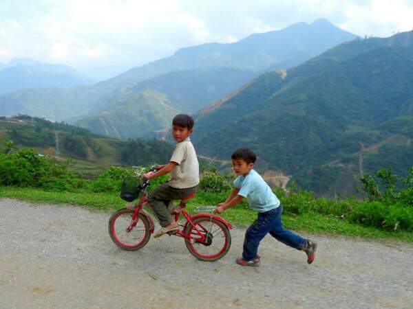 Des enfants jouent avec un vélo, dans le nord du Vietnam.