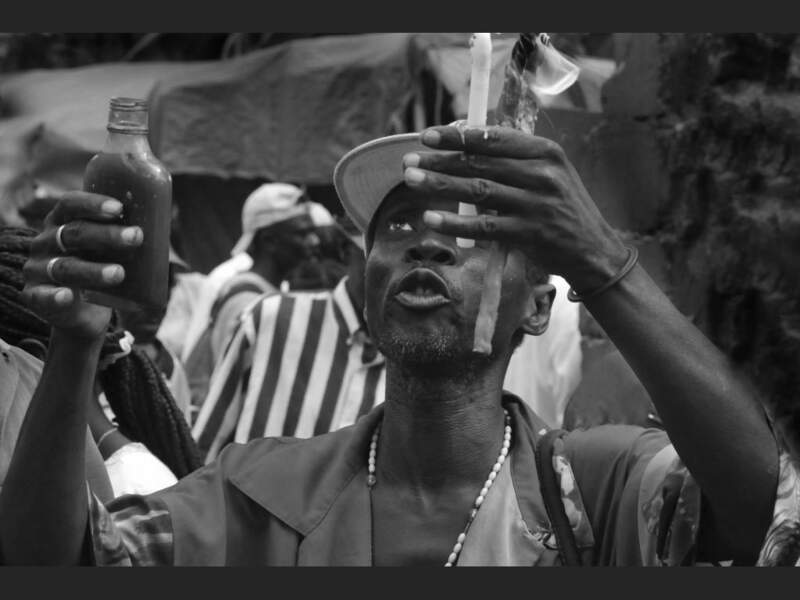 Un homme prie le dieu Ogou (Haïti).