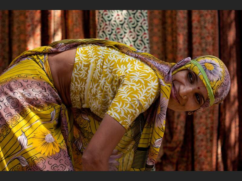 Une femme en sari ramasse des tissus dans une usine textile de la banlieue de Jaipur, au Rajasthan, en Inde. 