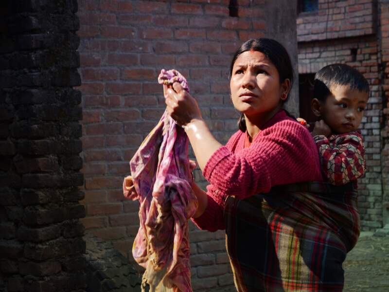 Dans une petite rue de Bhaktapur, au Népal, une femme et son enfant