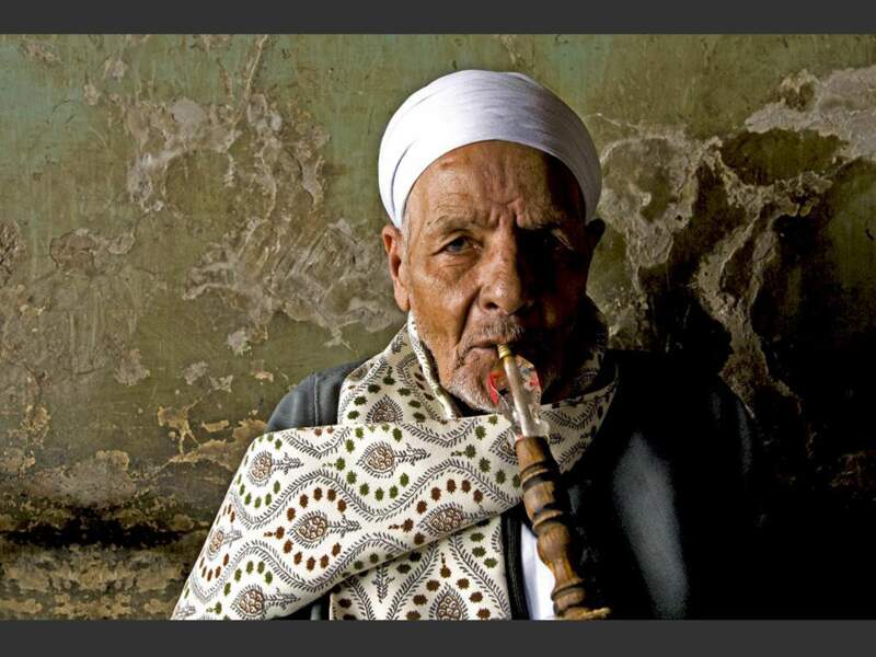 Un vieil homme fume la chicha dans un café du Caire, en Egypte.
