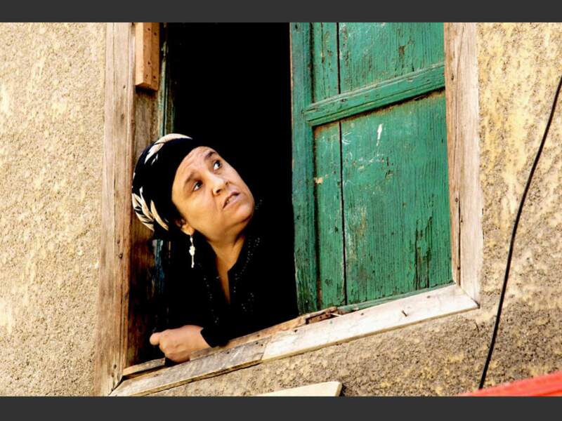 Une habitante du Caire regarde par sa fenêtre (Egypte).