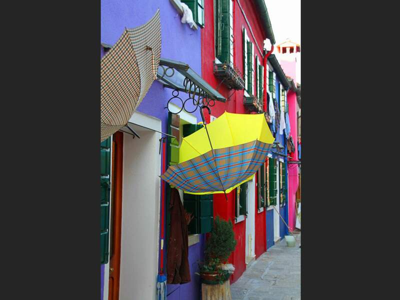 Les parapluies et les façades donnent une impression de gaité et de spontanéité sur l'île de Burano, à Venise, en Italie.