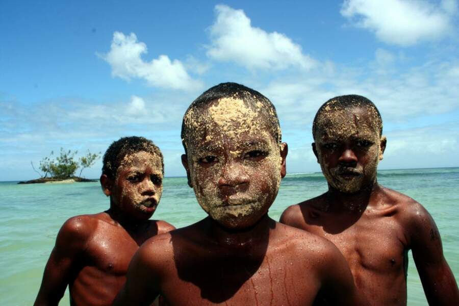 Sur la plage de l’île Sainte-Marie, des enfants se couvrent le visage de sable pour jouer les durs.