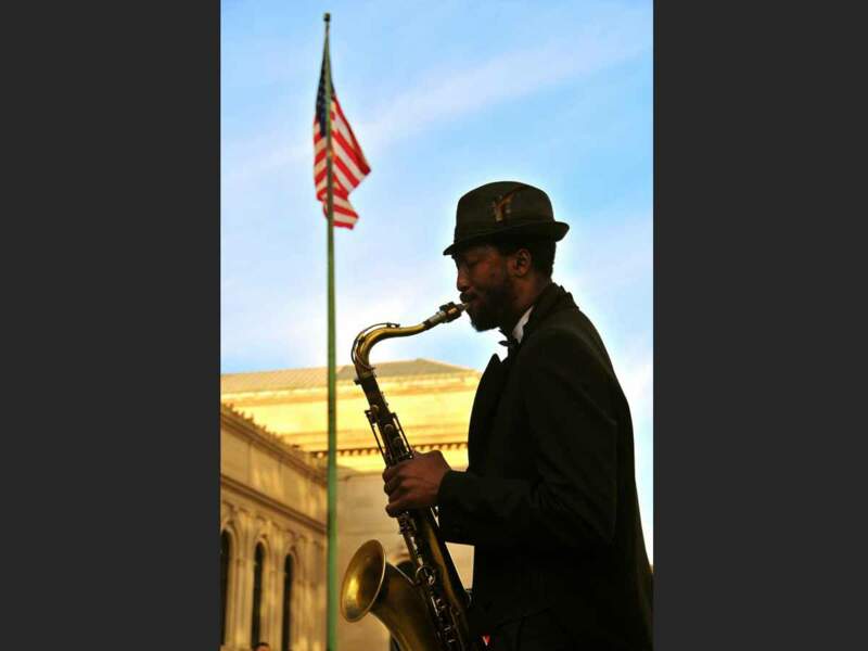 Un saxophoniste joue devant le Met, à New York, aux Etats-Unis.