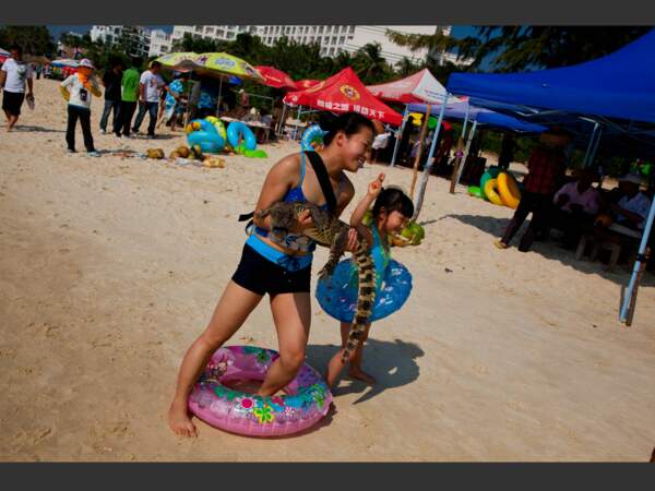 Sur la plage populaire de Sanya, sur la côte sud, se faire prendre en photo avec un caïman est un must (Hainan, Chine).