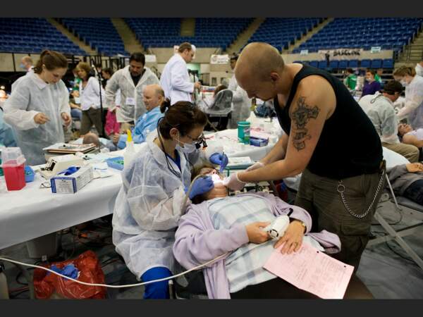 Un homme donne un coup de main à la dentiste qui soigne sa mère (université de Lincoln, Harrogate, Tennessee, Etats-Unis). 