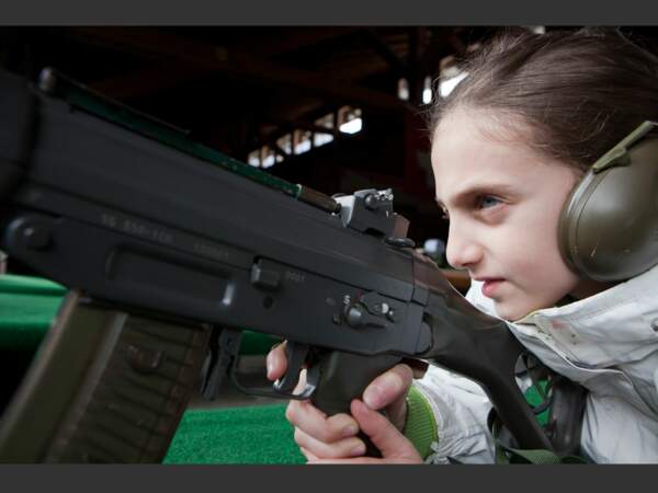 A neuf ans, Michelle sait déjà viser avec un fusil d’assaut de l’armée suisse.