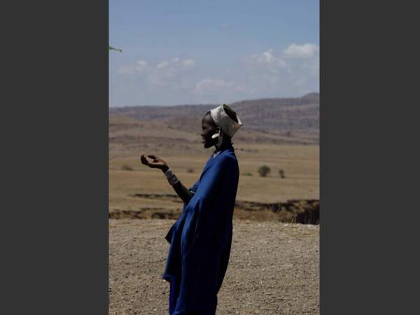 Une jeune femme massaï vêtue de bleu, symbole de sagesse, observe la plaine en Tanzanie.