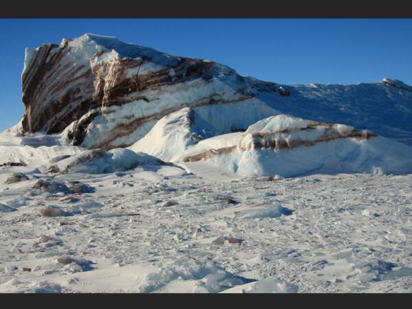Cette couleur marron est due à l'incrustation de roche dans l'iceberg, phénomène courant en Terre Adélie (Antarctique).