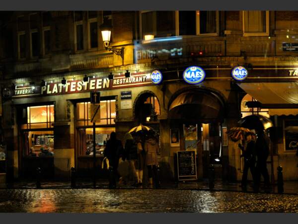 Des passants devant un bar de Bruxelles, en Belgique.
