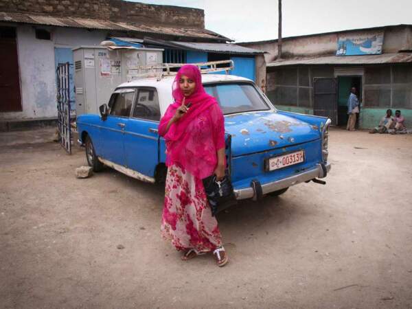 Portrait d'une femme devant un taxi d'Harar, en Ethiopie