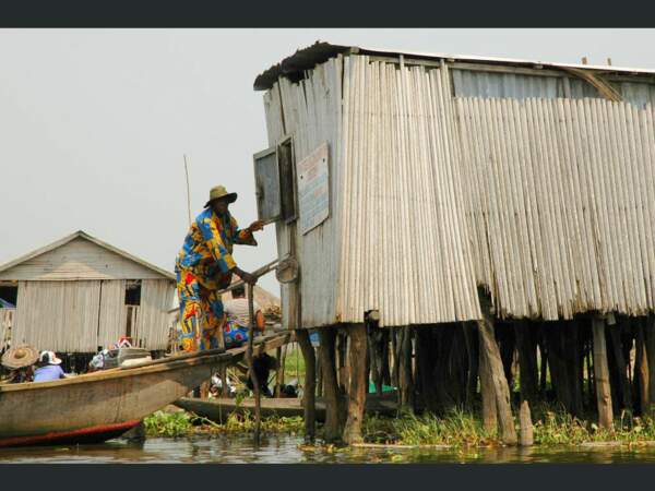 Un homme tente d’accéder à une habitation dans le village de Ganvié, au Bénin.