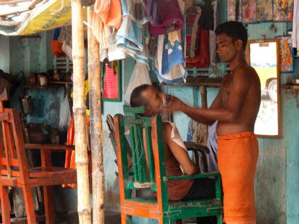 Un barbier de Calcutta s’occupe d’un client (Inde).