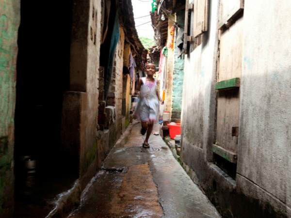 Dans une ruelle de Calcutta, en Inde, cette petite fille se met à courir en voyant l’appareil photo.