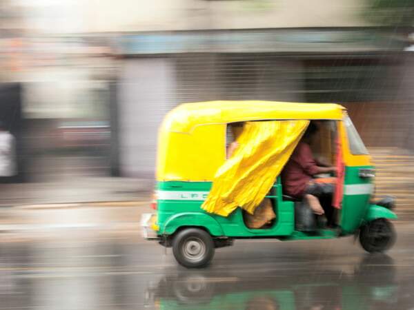Un tuk-tuk file à travers New Delhi, en Inde. 