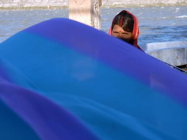 Une femme étend son sari dans le vent.