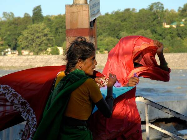 Deux femmes luttent contre le vent pour mettre leurs saris.