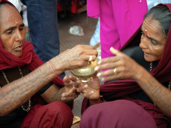 Deux femmes se disputent un pot dans un commerce d’Har Ki Pauri.