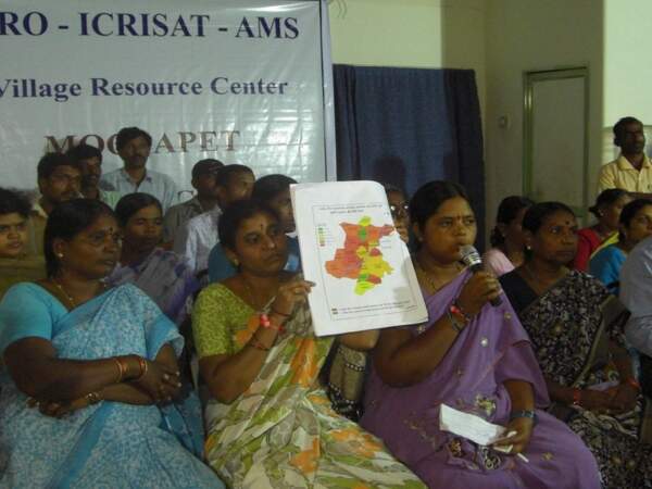 Une formatrice volontaire montre une carte des risques de sécheresse lors d'une vidéoconférence avec l'ICRISAT à Addakal Mandal, Andhra Pradesh, en Inde
