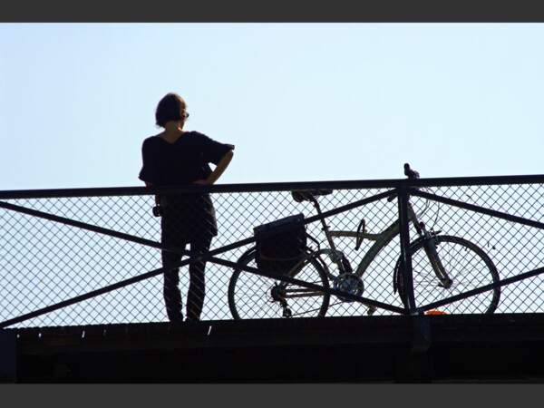 Sur le pont des Arts, à Paris, cette cycliste admire la Seine.
