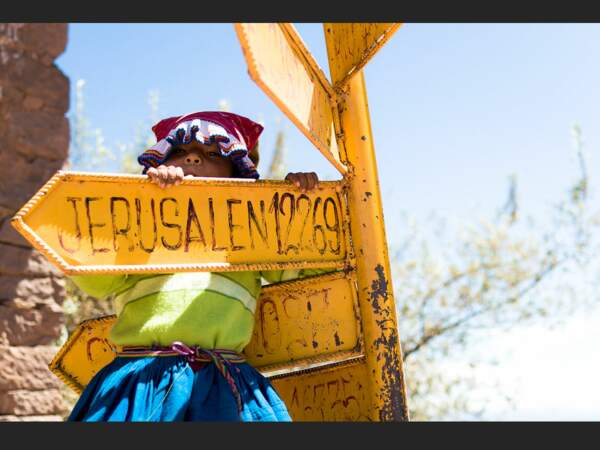 La même petite fille joue avec un panneau indiquant la direction de Jérusalem, sur l'île de Taquile, sur le lac Titicaca (Pérou).