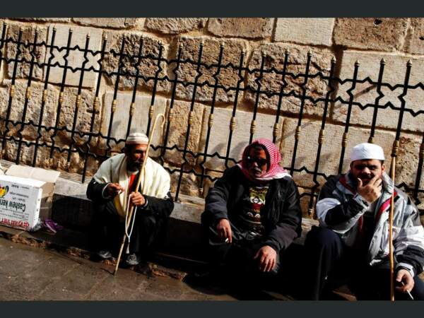 Trois hommes discutent autour d’une cigarette, à Alep, en Syrie.