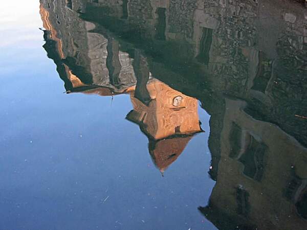Une tour du palais de l'Isle, à Annecy, se reflète dans les eaux du Thiou