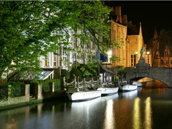 Ces bateaux promènent chaque jour les touristes le long des canaux de Bruges, en Belgique.