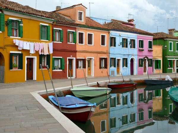 Des bateaux amarrés le long du canal de Burano, dans la lagune de Venise, en Italie
