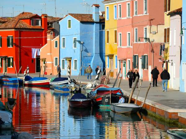 Des passants au bord de l'un des canaux de Burano, dans la lagune de Venise, en Italie
