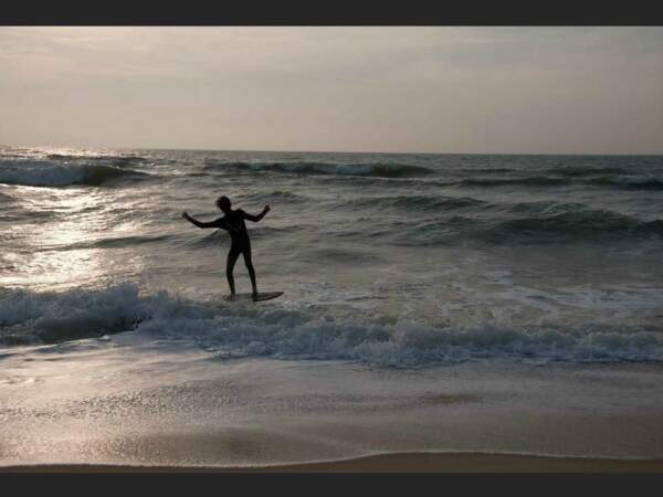 Surfeur glissant sur les vagues en fin d'après-midi à Lacanau, en Gironde.