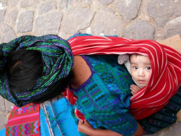 Un bébé tranquillement installé sur le dos de sa mère, à Antigua, au Guatemala. 