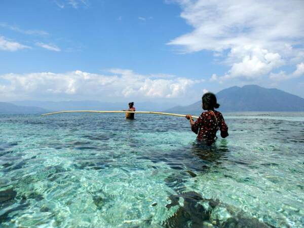 Deux pêcheuses dans les eaux limpides de l'île de Pantar, dans les petites îles de la Sonde, sur l'archipel d'Alor, en Indonésie