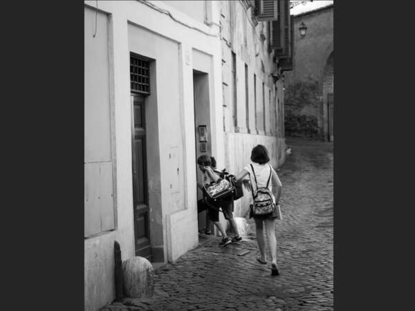 Enfants qui s'engouffrent dans leur école au petit matin, dans le quartier du Trastevere, à Rome, en Italie. 