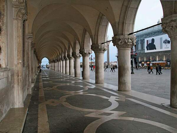 Sous les arcades du palais des Doges, à Venise, en Italie.