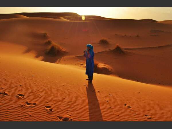 Un jeune Targui prend en photo les touristes pendant une balade dans le désert, au Maroc.