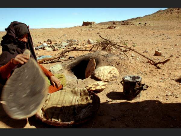 Une femme fait cuire son pain dans les environs de Merzouga, au Maroc.