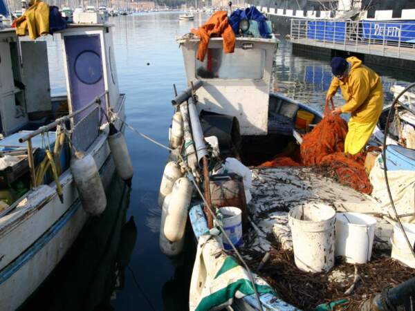 Un pêcheur dénoue ses filets dans le Vieux Port de Marseille, en Provence-Alpes-Côtes d’Azur, en France